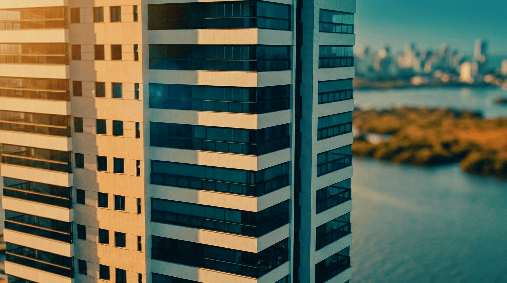 Detalhe das varandas e fachada envidraçada do Edifício Miguel Carrilho com vista para o rio