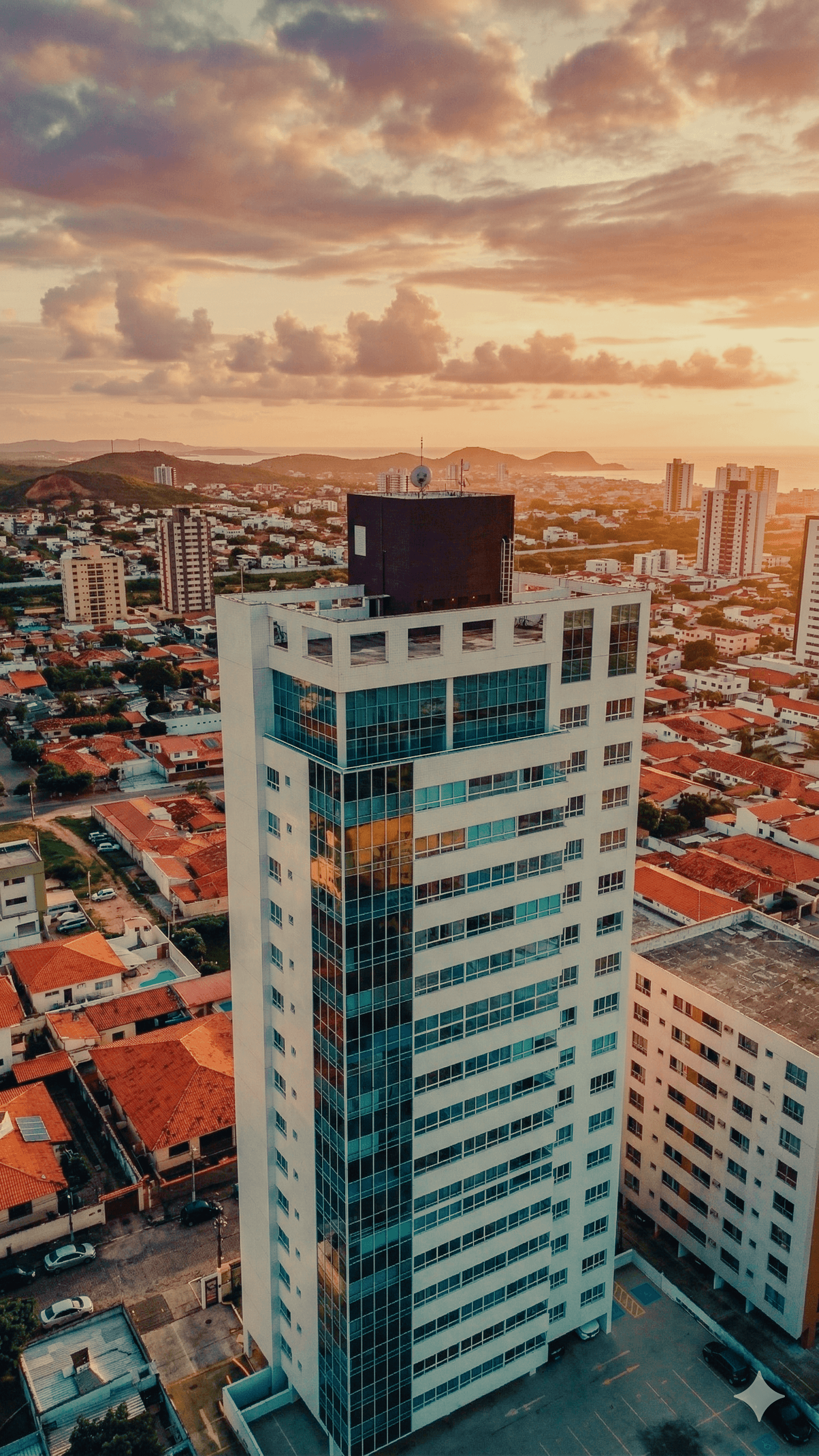 Vista aérea do Edifício Themis ao entardecer com panorama da cidade de Natal ao fundo