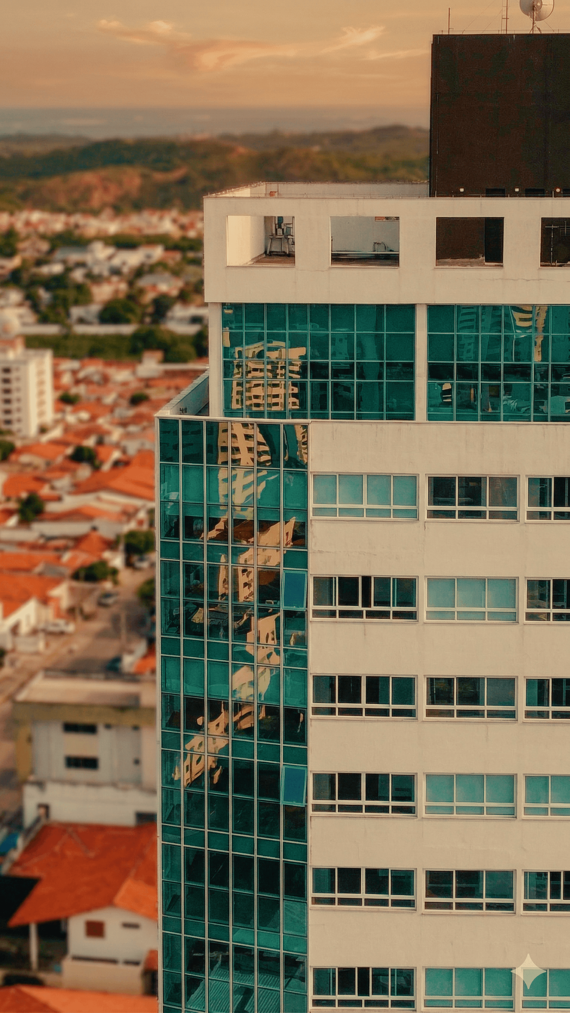Detalhe da fachada envidraçada do Edifício Themis com reflexos da cidade de Natal